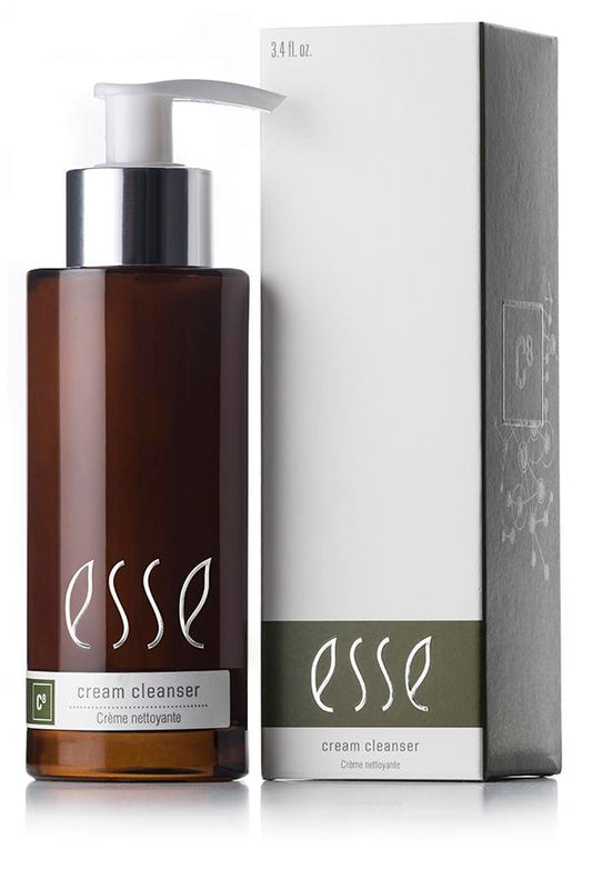 En 200 ml brun pumpeflaske med Esse Cream Cleanser fra Hudkonsulenten Monrad-Krohn står ved siden av den matchende esken, begge med "esse" i små bokstaver og produktnavnet under.
